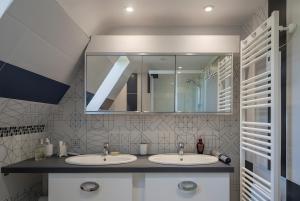 a bathroom with two sinks and a mirror at Gîte Les Sapins Douglas in Sansac-Veinazés +3 photos