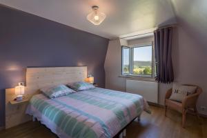 a bedroom with a large bed and a window at Gîte Les Sapins Douglas in Sansac-Veinazés