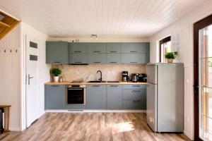 a kitchen with blue cabinets and a refrigerator at Mehrblick Kopice in Stepnica