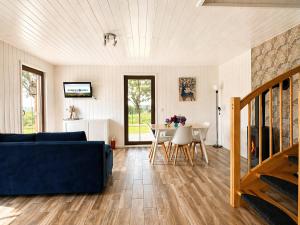 a living room with a blue couch and a table at Mehrblick Kopice in Stepnica