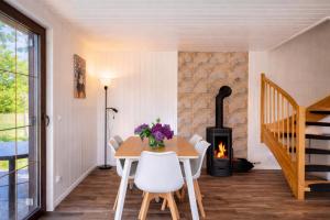a dining room with a table and a wood stove at Mehrblick Kopice in Stepnica