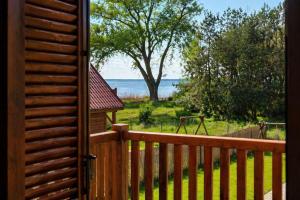 a door to a deck with a view of the water at Mehrblick Kopice in Stepnica +17 photos
