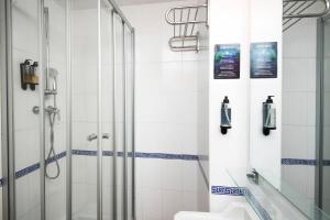 a bathroom with a shower and a toilet at Hotel Caleta in Lloret de Mar +55 photos