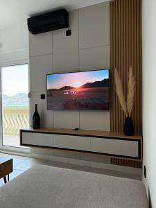 a living room with a flat screen tv on a wall at Lakeside house in Podgorica