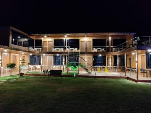 a building with a lawn in front of it at night at Arya Resort And Spaa in Mahabaleshwar