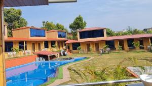 a resort with a swimming pool in front of a building at Arya Resort And Spaa in Mahabaleshwar