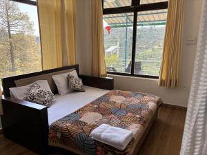 a bed in a room with a large window at The Plum in Mukteshwar