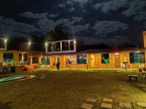 a person standing in front of a building at night at Arya Resort And Spaa in Mahabaleshwar