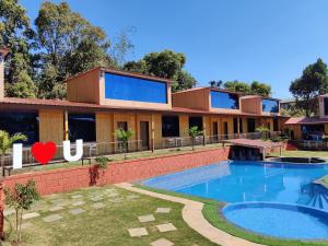 a house with a swimming pool in front of it at Arya Resort And Spaa in Mahabaleshwar