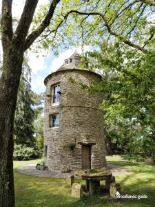 an old stone tower with a door in a park at Le Moulin de Bréhaut in Augan