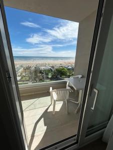 Blick auf einen Balkon mit Stuhl und Waschbecken in der Unterkunft Hotel Soave in Cervia