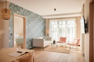 a living room with a couch and a table and chairs at Gezeiten Suites Büsum - Neueröffnung in Büsum