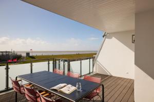 a table and chairs on a balcony with a view of the beach at Gezeiten Suites Büsum - Neueröffnung in Büsum
