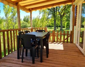 a wooden deck with a table and chairs on it at Parc- Camping de Coullons in Coullons