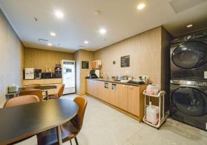 eine Küche mit Tisch und Waschmaschine und Trockner in der Unterkunft Rosy Hotel in Cheongju