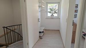 a hallway with a staircase with a window and a plant at Residenz Agnes in Beckingen +52 photos