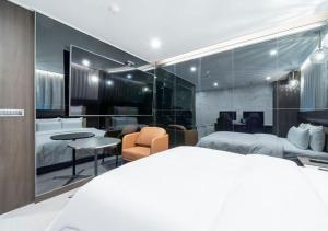 ein Hotelzimmer mit Bett, Tisch und Stühlen in der Unterkunft Rosy Hotel in Cheongju