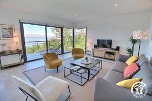 a living room with a couch and chairs and a television at Brise marine in Trébeurden