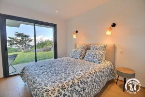 a bedroom with a bed and a large window at Brise marine in Trébeurden