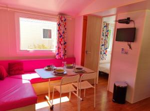 a living room with a pink couch and a table at Parc- Camping de Coullons in Coullons