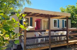 a tiny house with a porch and a deck at Parc- Camping de Coullons in Coullons