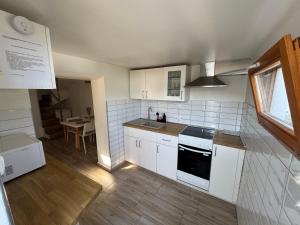 a kitchen with white cabinets and a stove top oven at Paloznak Panoráma in Paloznak