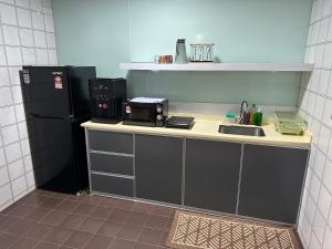 a small kitchen with a sink and a refrigerator at The Regency PortDickson A1-6 in Port Dickson