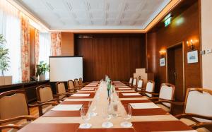 a long table in a room with chairs and a whiteboard at Grand Hotel Cravat in Luxembourg