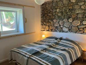 a bedroom with a bed and a stone wall at Villa Lugina in Fushë-Buall