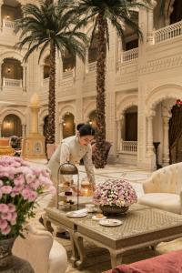 a woman in a room with a table with flowers at Raffles Jaipur in Jaipur +188 photos