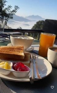 a plate of food with toast and fruit on a table at Hotel PeaceFul in Bandipur