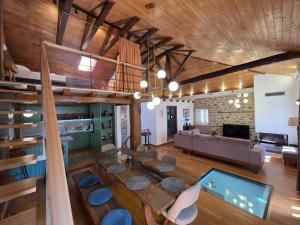 an open living room with a stone wall and wooden ceilings at Elia City House in Kavála