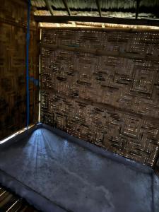 a room with a brick wall and a floor at Cat Hut Farmstay in Ban Khok Yom