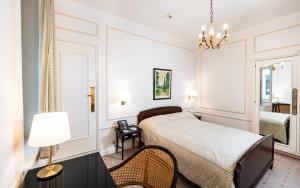 a bedroom with a bed and a table and chairs at Grand Hotel Cravat in Luxembourg