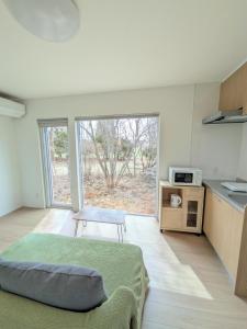 a room with a kitchen with a table and a microwave at cottage hapo in Higashikagura