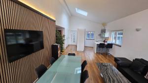 a living room with a table and a television on a wall at SUITE in Brienz