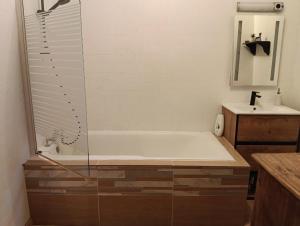 a bathroom with a tub and a sink at Au coeur d'Harfleur in Harfleur