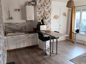 a kitchen with a table and chairs in a room at Au coeur d'Harfleur in Harfleur