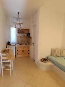 a bedroom with a bed and a table and a kitchen at Athina Studio Apartments in Kerveli