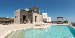 a villa with a swimming pool in front of a building at Amaranthine Villa in Imerovigli