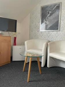 a living room with two chairs and a coffee table at Penzion U Kašných in Mníšek pod Brdy