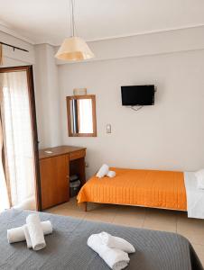 a bedroom with two beds and a tv on the wall at Άλκηστις Alkistis in Loutra Edipsou