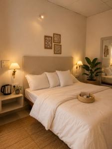 a bedroom with a large white bed with a basket on it at Bir Haus in Bīr +72 photos