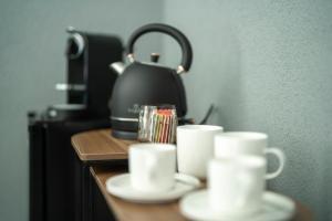 a table with cups and a tea kettle on it at Rezidence 14 Nový Bor in Nový Bor
