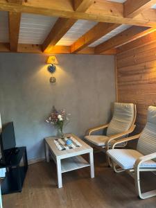 a living room with two chairs and a table at Omazot au calme dans verdure in Aix-les-Bains