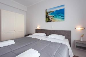 a bedroom with two beds and a painting on the wall at Balaris Apartments in Kassiopi
