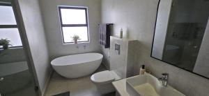 a bathroom with a tub and a toilet and a sink at Sage & Salt in St. Helena Bay +16 photos