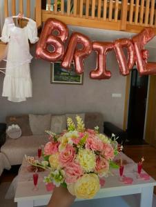 a table with a bouquet of flowers and a sign that says beta at Vikendica Šehić in Zavidovići