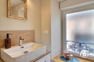 a bathroom with a sink and a mirror and a window at Le clos des sittelles in Theix +29 photos