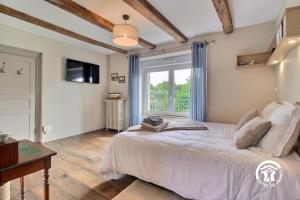 a bedroom with a large bed and a window at Le clos des sittelles in Theix